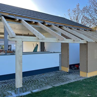 Holzbau mit Dachstuhl und offenem Bereich, vorbereitet für den weiteren Ausbau.