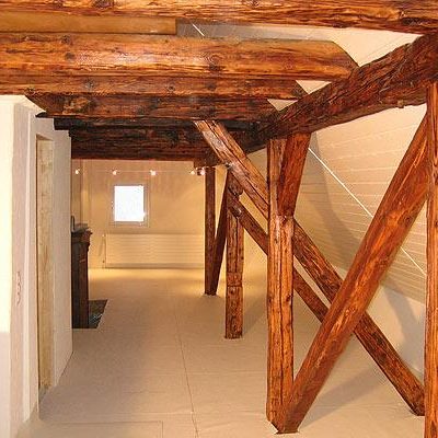 Ausgebauter Dachboden mit Fachwerk und hellen Wänden, gepflegte und offene Atmosphäre.